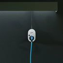 An einer Wand montierter go-e charger gemini 11kw mit angestecktem Typ 2 Ladekabel während eines Ladevorganges.